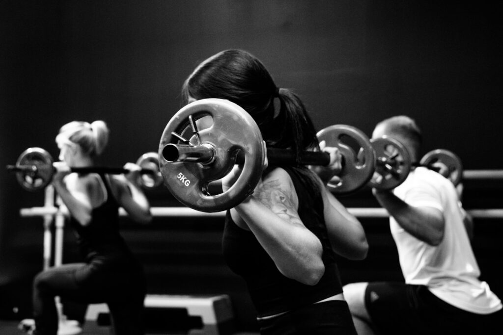 three person lifting barbels